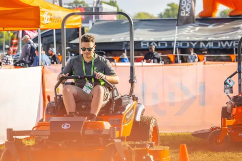 Archive photograph of a visitor testing a mower at Equip Exposition