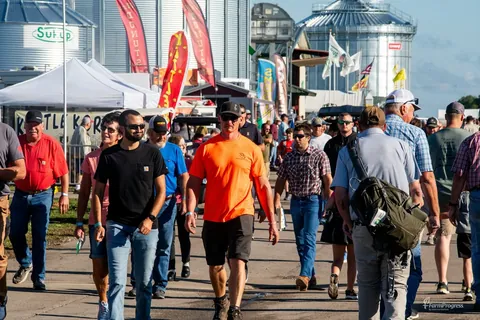 Visitors walking past machinery and grain-storage exhibits at Farm Progress Show in Decatur