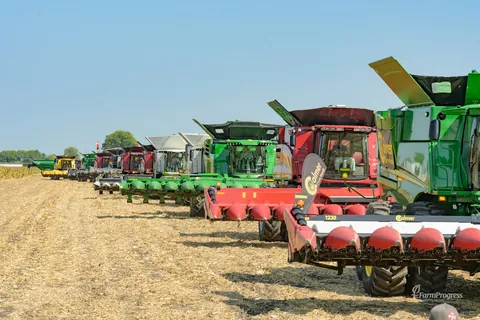 Combines and harvesting equipment lined up in a field at Farm Progress Show in Decatur